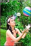 Olive Moon Playing With Ball In Garden Wearing Sun Visor And Orange Top