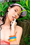 Thai Girls Biting Finger Sitting Topless Against Tree Stump Wearing Colourful Bangles