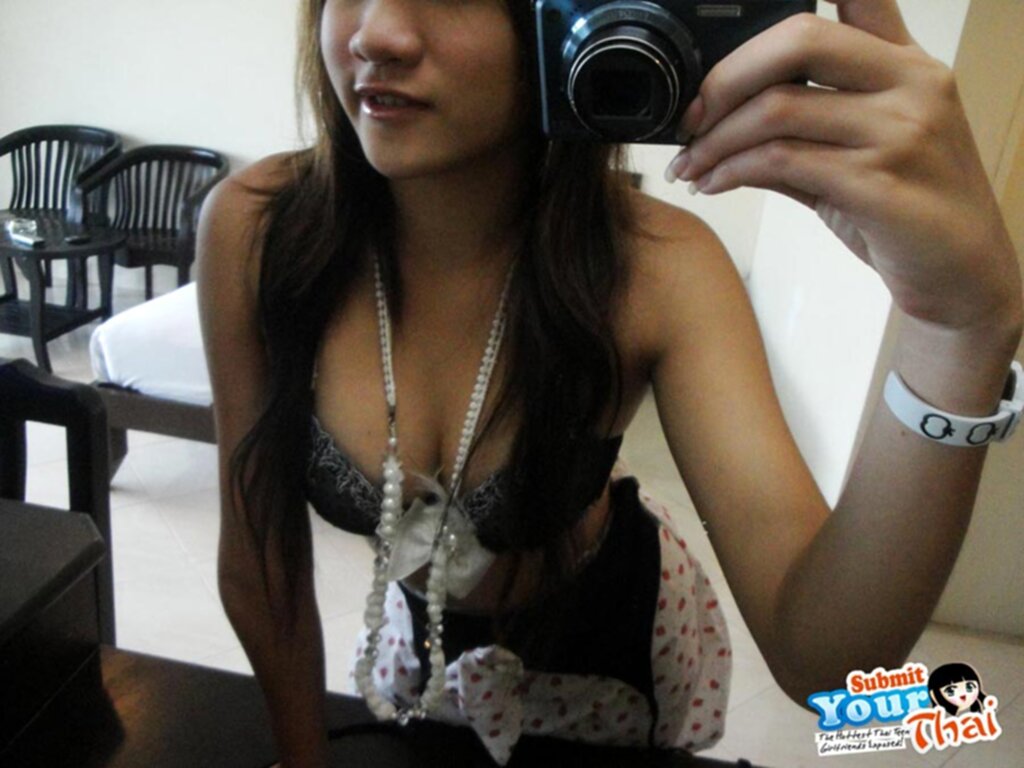 Necklace falling between her breasts in bra taking a self shot picture