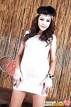 Standing with arms down by her sides wearing silver dress