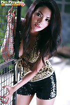 Pim Pimpilai leaning against metal gate long hair wearing shorts painted fingernails
