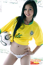 Long hair falling over her brazil football shirt clutching a ball under her arm hand on hip wearing white panties