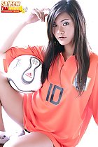 Seated with ball long hair over orange football shirt