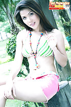 Sitting on tree stump wearing bikini top in shorts
