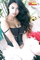 Seated in lingerie holding feather boa