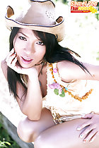 Squatting in dress proppping face in her hand hand on thigh