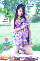 Kneeling on picnic blanket wearing dress