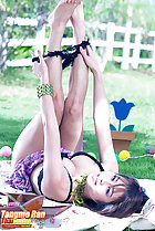 Lying on her back legs raised bare feet pulling panties off