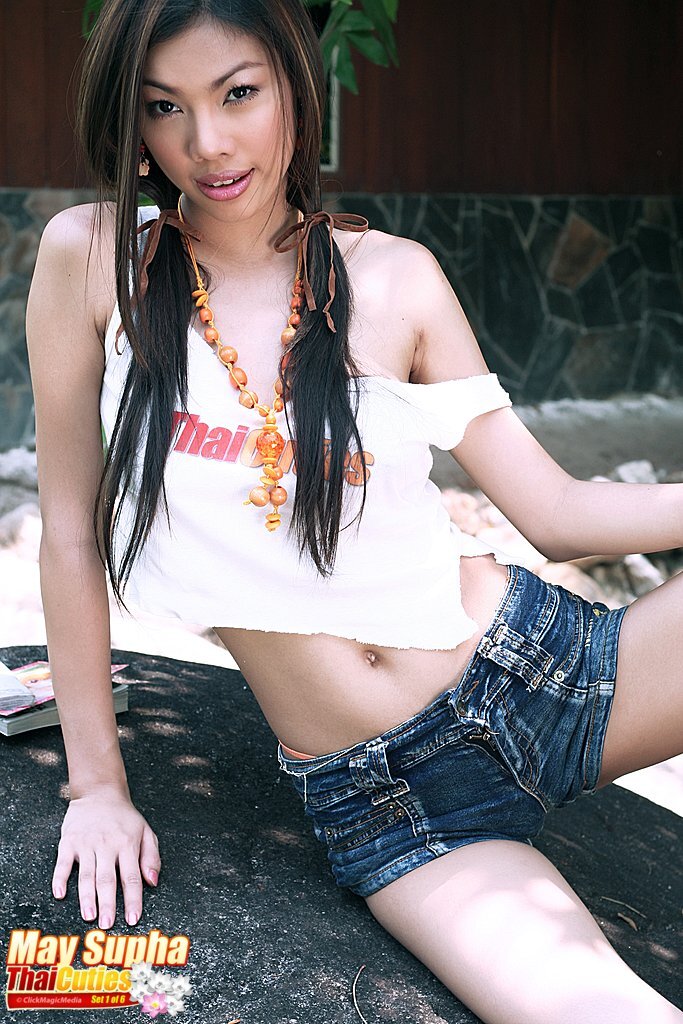 May supha sitting on rock long hair in pigtails wearing denim shorts